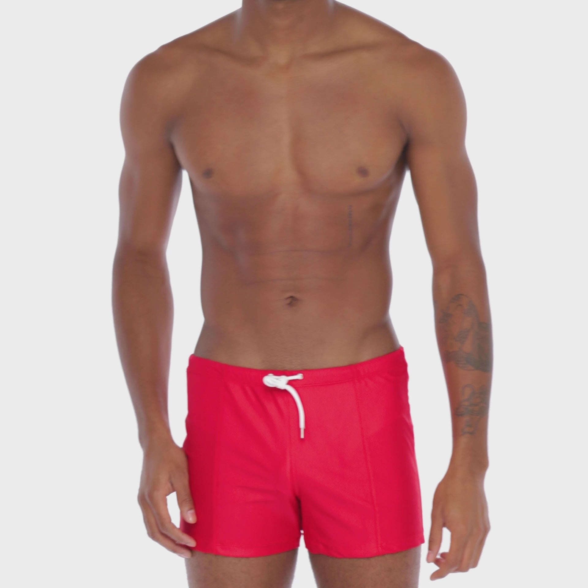 A WHITE WALL VIDEO OF A MALE MODEL WEARING A SAMMY SHOP UNISEX CHERRY ECO SWIM TRUNK