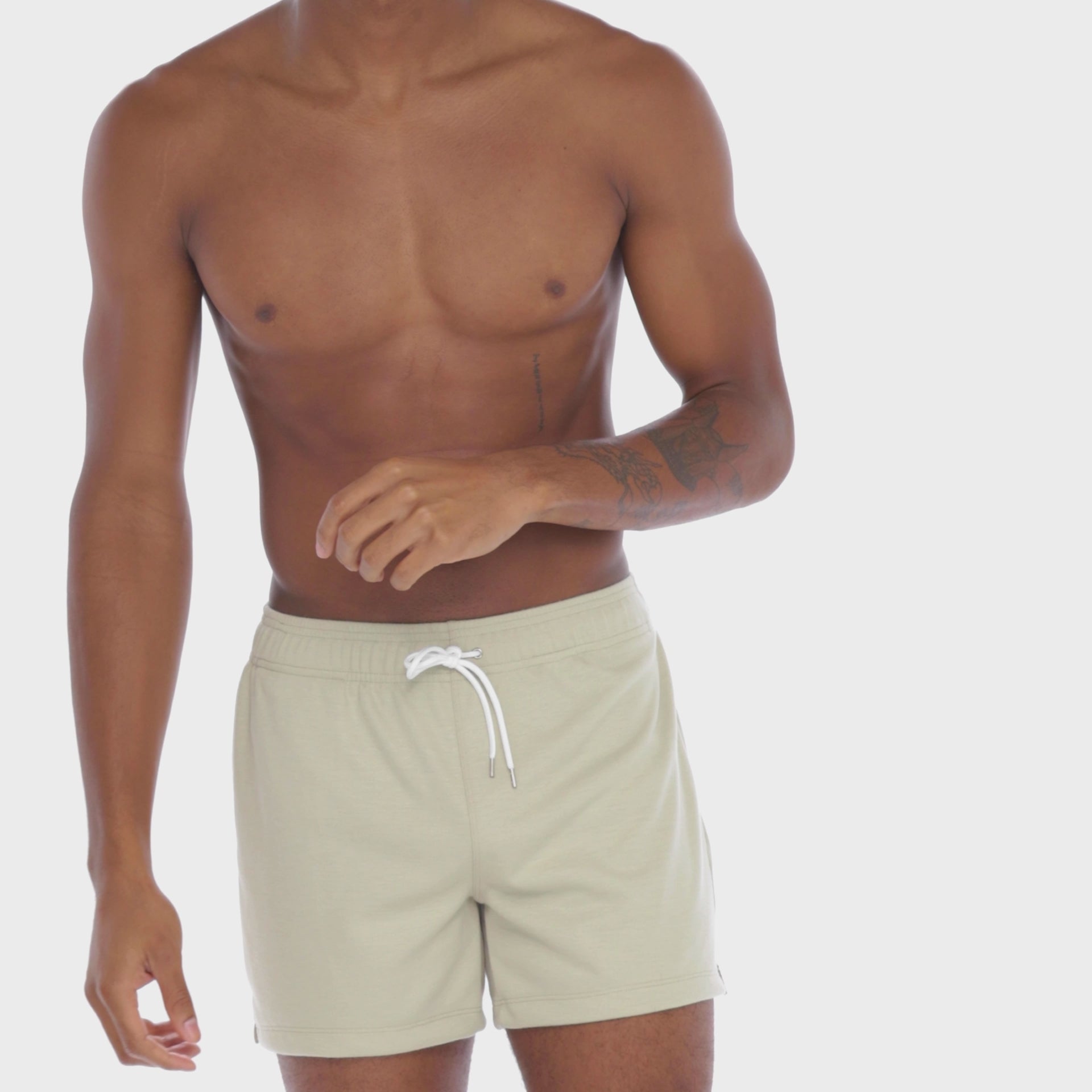 A WHITE WALL VIDEO OF A MALE MODEL WEARING THE SAMMY SHOP UNISEX SWEAT SHORT IN SAND