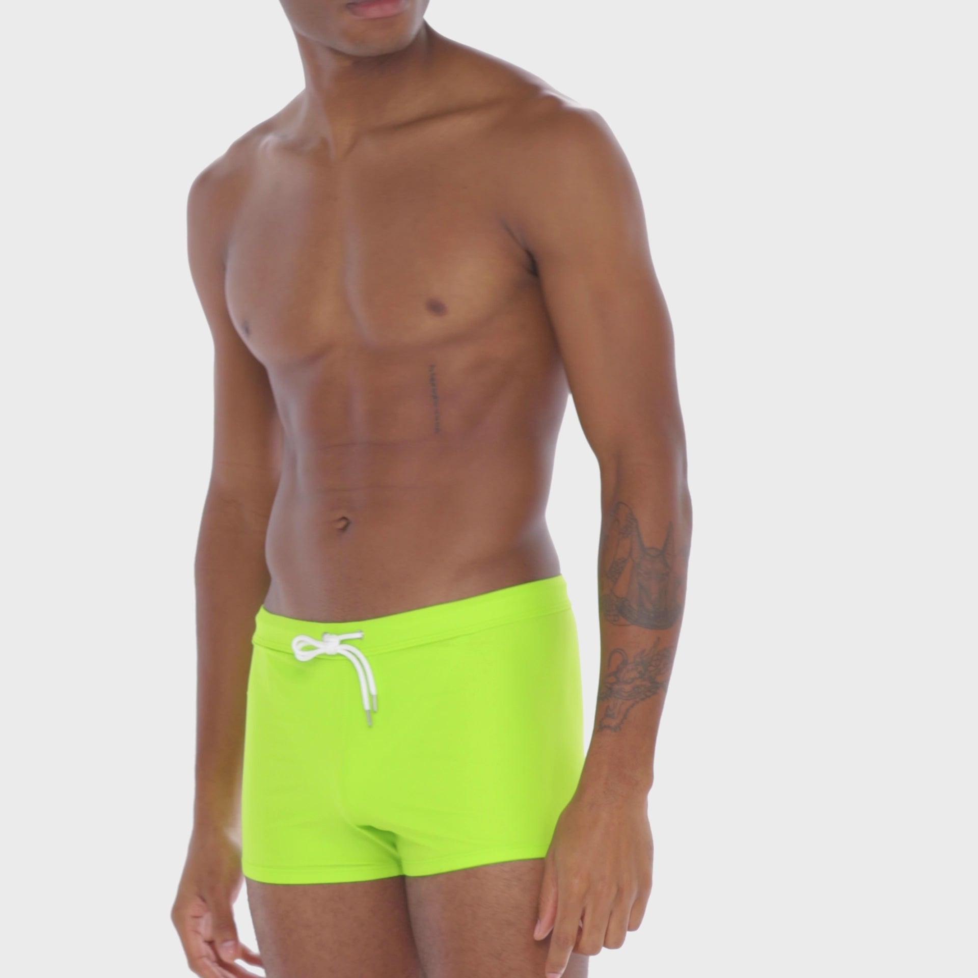 A WHITE WALL VIDEO OF A MALE MODEL WEARING A SAMMY SHOP UNISEX LIME ECO SWIM SHORT