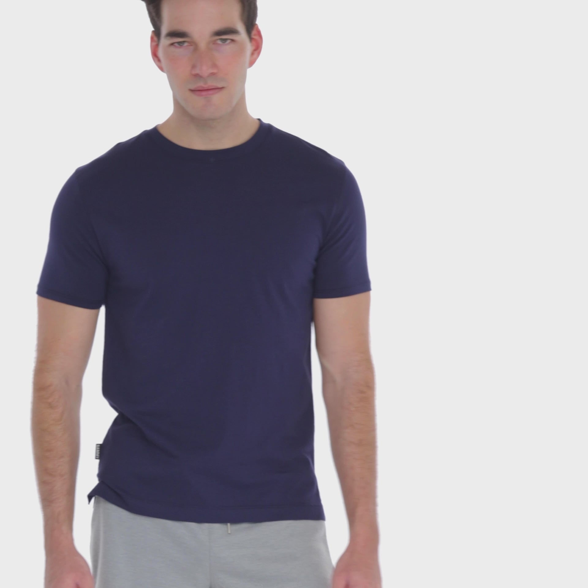 A WHITE WALL VIDEO OF A MALE MODEL WEARING THE SAMMY SHOP UNISEX NAVY EVERYDAY T-SHIRT