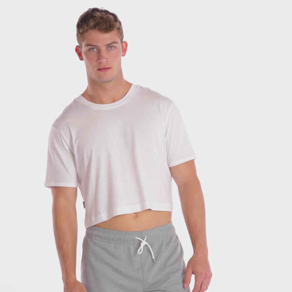 A WHITE WALL VIDEO OF A MALE MODEL WEARING THE SAMMY SHOP UNISEX WHITE MIDRIFF CROP T-SHIRT