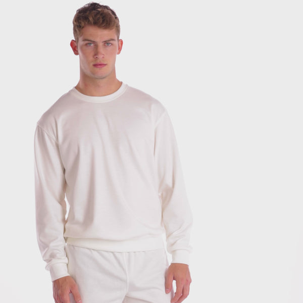A WHITE WALL VIDEO OF A MALE MODEL WEARING THE SAMMY SHOP UNISEX SNOW EVERYDAY CREW SWEATSHIRT